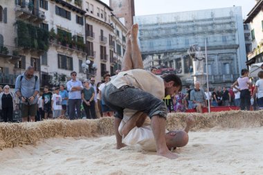 VERONA, ITALY, NOVEMBER, 14, 2019: (Tocat - Uluslararası Sokak Oyunları Festivali), Geleneksel Brittany Oyunları, Breton güreşi, kum ringinde dövüşen iki adam, Lutte Bretonne