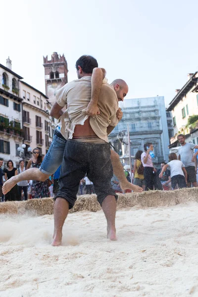 VERONA, ITALY, NOVEMBER, 14, 2019: (Tocat - Uluslararası Sokak Oyunları Festivali), Geleneksel Brittany Oyunları, Breton güreşi, kum ringinde dövüşen iki adam, Lutte Bretonne