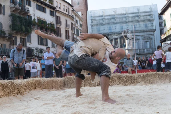 VERONA, ITALY, NOVEMBER, 14, 2019: (Tocat - Uluslararası Sokak Oyunları Festivali), Geleneksel Brittany Oyunları, Breton güreşi, kum ringinde dövüşen iki adam, Lutte Bretonne