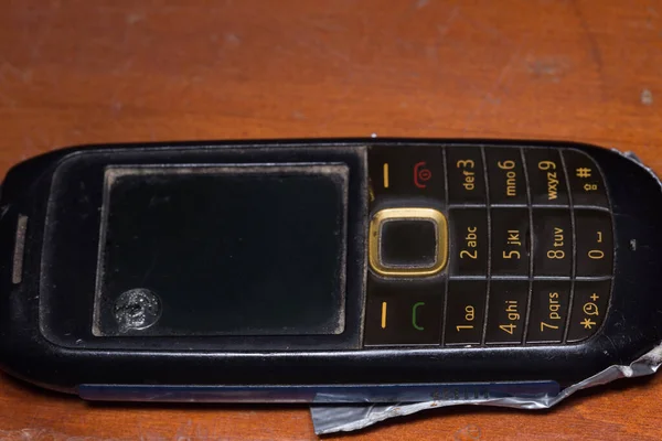 破了的旧手机 有黄色钥匙的黑色手机 — 图库照片
