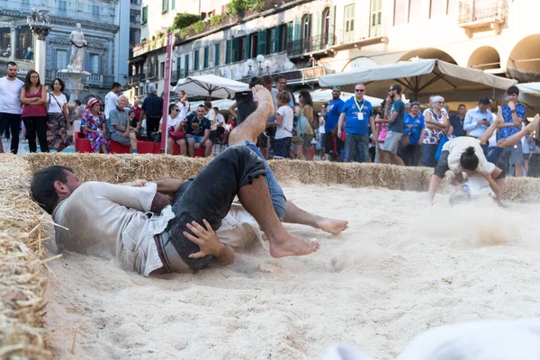 VERONA, ITALY, NOVEMBER, 14, 2019: (Tocat - Uluslararası Sokak Oyunları Festivali), Geleneksel Brittany Oyunları, Breton güreşi, kum ringinde dövüşen iki adam, Lutte Bretonne