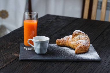 Kafe portakal suyu ve brioche kırsal masada, sağlıklı kahvaltı konsepti.