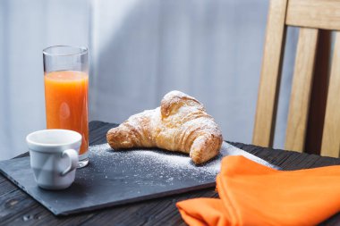 Kafe portakal suyu ve brioche kırsal masada, sağlıklı kahvaltı konsepti.