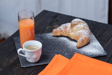 Kafe portakal suyu ve brioche kırsal masada, sağlıklı kahvaltı konsepti.