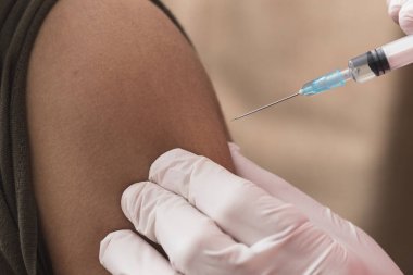 Hastaya iğne yapmak için şırıngayı tutan hemşire. Covid-19 veya koronavirüs aşısı