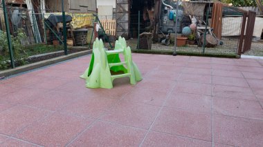 Bahçede yeşil ve gri fayanslar var.