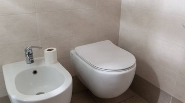 Tuvalet musluğu ve seramik kase banyoda.