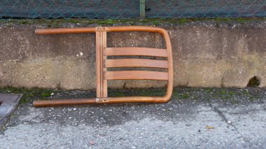 Yerdeki paslı metal koltuk.