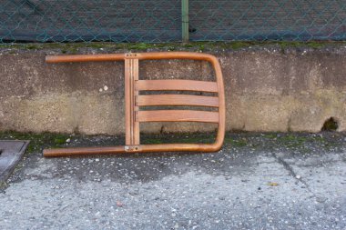 Tahta sandalye dışarıda yerde yatıyor..