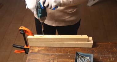 İnsan ve Matkap Ucu Tahtada Delik Açıyor.