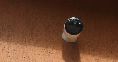 Beyaz kablosuz güvenlik kamerası Kırmızı Duvara monte edildi.