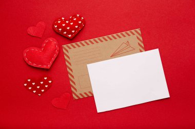 Valentine's day greeting card envelope with red hearts on red background. Top view, copy space, love concept