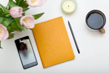 Not defteri, telefon, kahve ve çiçekli kadınların işyeri. Ev kavramından çalış