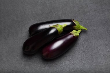 Koyu taştan arka planda çiğ patlıcan. Üst manzara. Sağlıklı vejetaryen yeme konsepti.