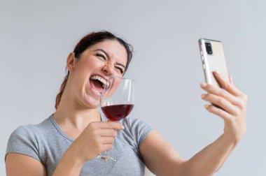 Beyaz bir kadın kırmızı şarap içer ve arkadaşlarıyla akıllı telefondan iletişim kurar. Karantinaya alınan kız, bayramı online bir konferans aracılığıyla kutluyor.