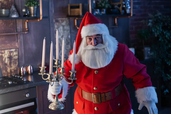 Санта Клаус подкрадывается ночью и держит канделябр. — стоковое фото