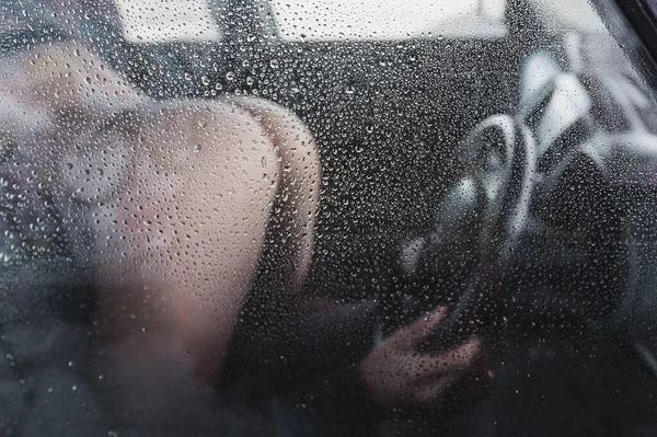 Tutkulu bir çift arabada sevişiyor. Sisli bir arabanın penceresinden bir adam ve bir kadının görüntüsü.