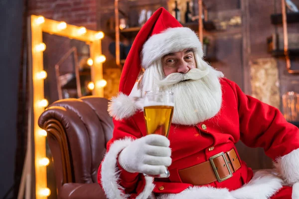 Santa Claus blahopřeje k Vánocům a vypije sklenici piva — Stock fotografie