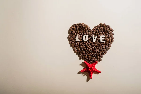 Widok z góry ziarna kawy w kształcie litery serca miłość i czerwone rozgwiazdy — Zdjęcie stockowe