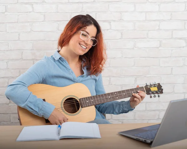 Mooie blanke vrouw speelt de gitaar live. Online muziektraining — Stockfoto