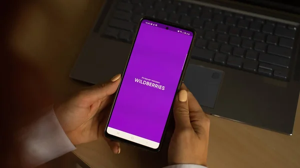 18. října 2020 Rusko, Novosibirsk: Žena používá aplikaci Wildberry na svém telefonu. Koncept nakupování online — Stock fotografie