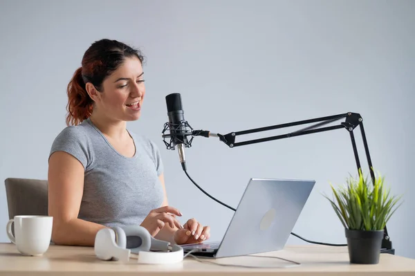 En charmig kvinnlig radiovärd sänder live på en bärbar dator. Radiokoncept online — Stockfoto