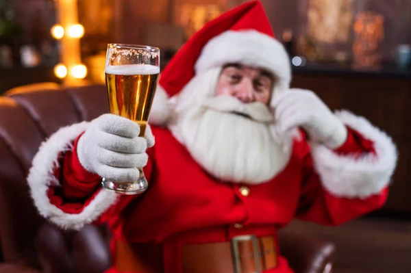 Santa Claus blahopřeje k Vánocům a vypije sklenici piva — Stock fotografie