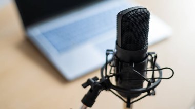 Bilgisayarın arka planındaki profesyonel bir mikrofona yakın plan. Radyo yayıncıları masaüstü