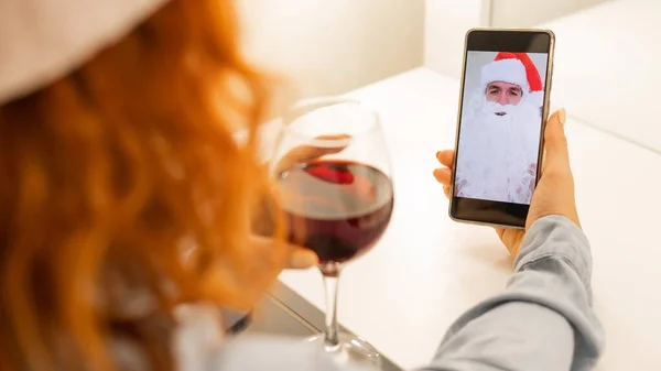 Mujer hace una videollamada a Santa Claus y bebe vino tinto en Navidad —  Fotos de Stock