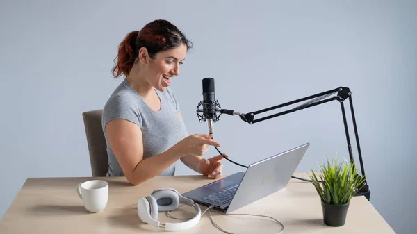 Eine charmante Radiomoderatorin überträgt live auf einem Laptop. Online-Radiokonzept — Stockfoto