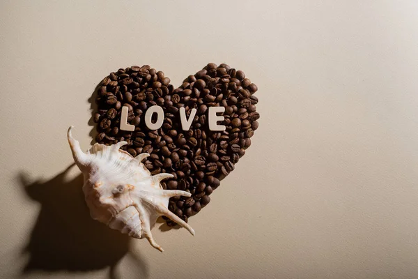 Coração em forma de grãos de café lettering amor e concha. Espaço de cópia. — Fotografia de Stock