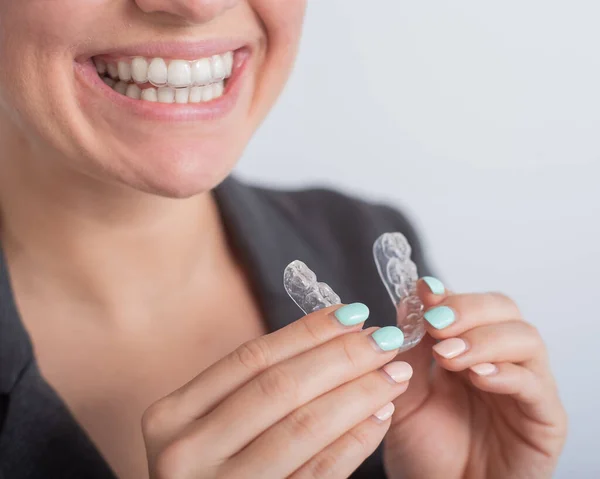 Mujer de negocios se pone retenedores transparentes para enderezar los dientes — Foto de Stock