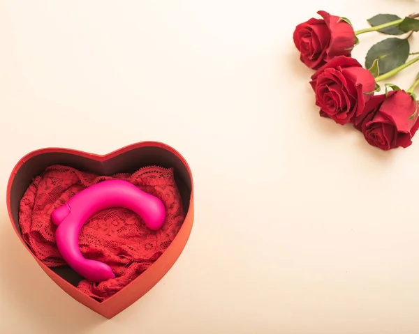 Sevgililer Günü 'nde ya da 8 Mart' ta bir kadına hediye. Vibratör ve iç çamaşırı bir kutuda, kalp şeklinde ve kırmızı güller. — Stok fotoğraf