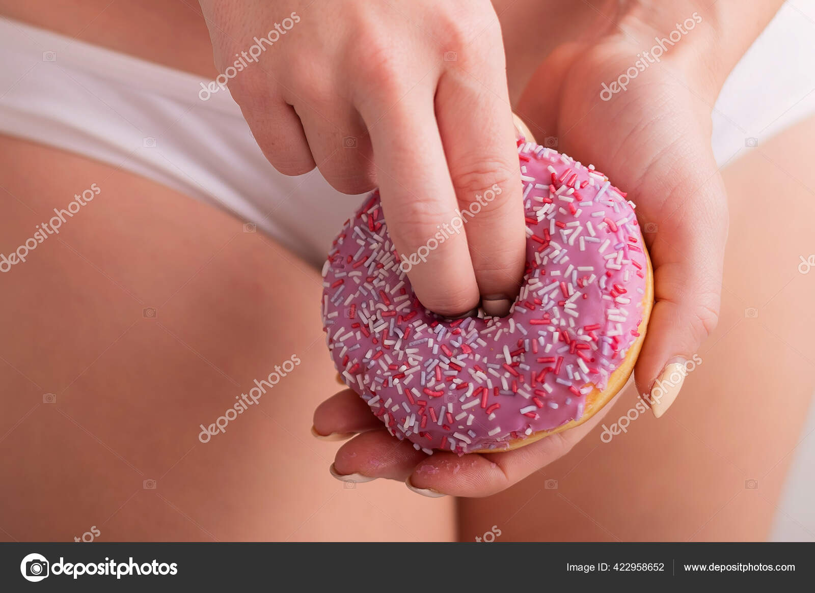 A faceless woman in white panties holds a pink donut imitating