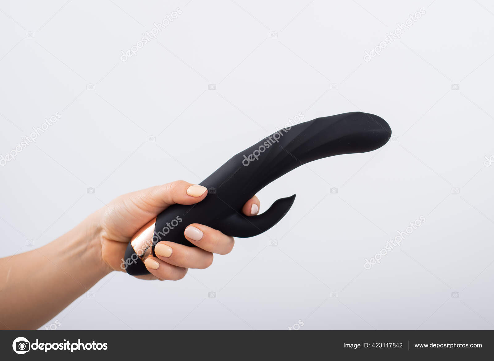 Faceless woman holding black dildo with clitoris stimulator on white background Stock Photo by ©inside-studio 423117842 pic
