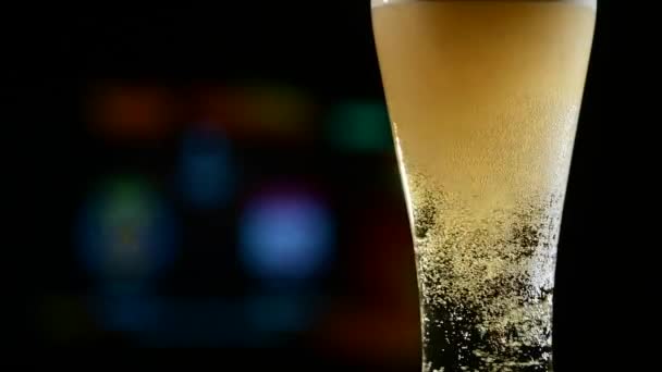 Gros plan de bière légère moussante fraîche dans un verre et de football à la télévision en arrière-plan. Concept de bar sportif — Video