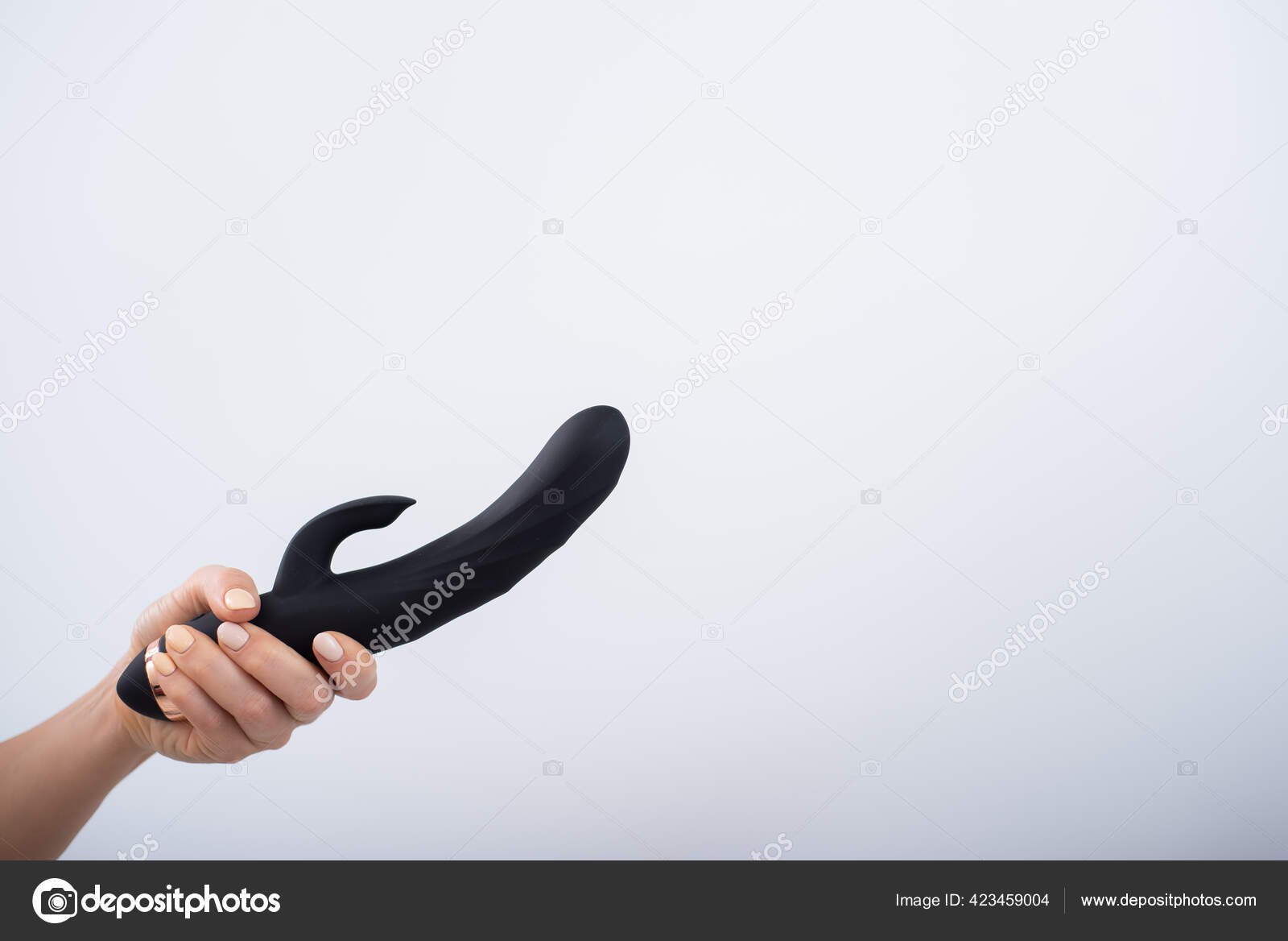 Faceless woman holding black dildo with clitoris stimulator on white background Stock Photo by ©inside-studio 423459004 picture