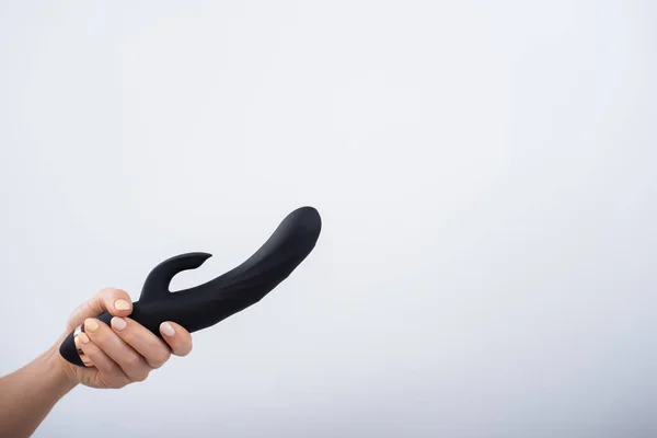 Faceless woman holding black dildo with clitoris stimulator on white background — Foto de Stock