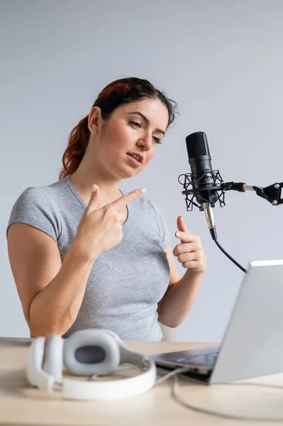 Eine charmante Radiomoderatorin überträgt live auf einem Laptop. Online-Radiokonzept — Stockfoto