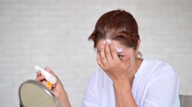 Vitiligo hastalığı olan beyaz bir kadının portresi güneş kremi kullanıyor.