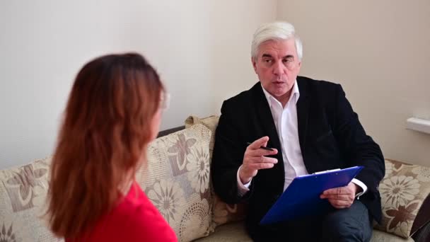 Un psicólogo anciano consulta a una paciente femenina. Sesión con un psicoterapeuta — Vídeos de Stock