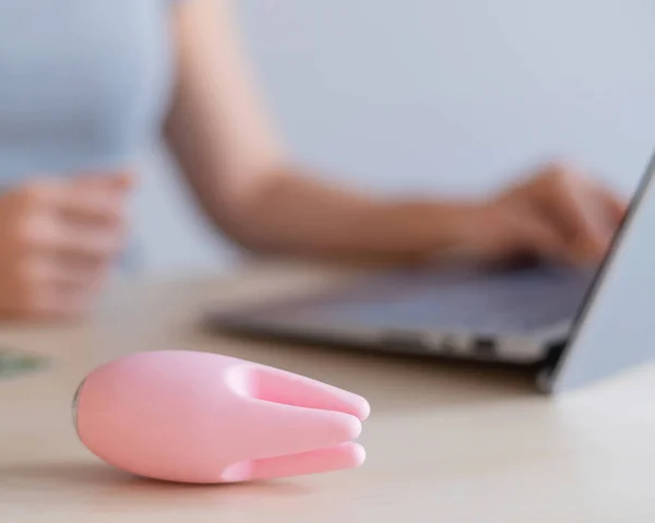 A woman watches porn on a laptop and masturbates. A faceless girl sits at a computer and holds a clitoral vibrator — Stock Photo, Image
