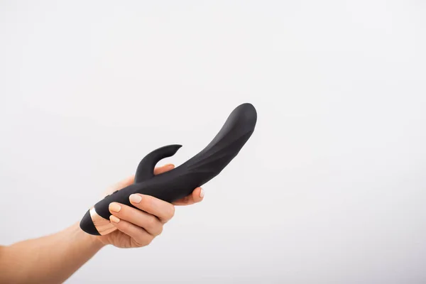 Faceless woman holding black dildo with clitoris stimulator on white background — Zdjęcie stockowe