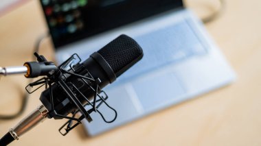 Bilgisayarın arka planındaki profesyonel bir mikrofona yakın plan. Radyo yayıncıları masaüstü