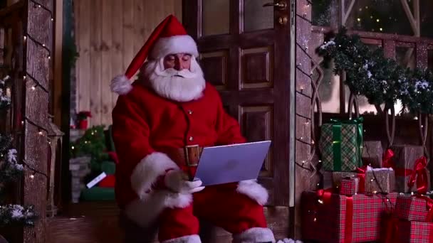 Счастливый Санта-Клаус удаленно желает счастливого Рождества в видеочате на ноутбуке — стоковое видео