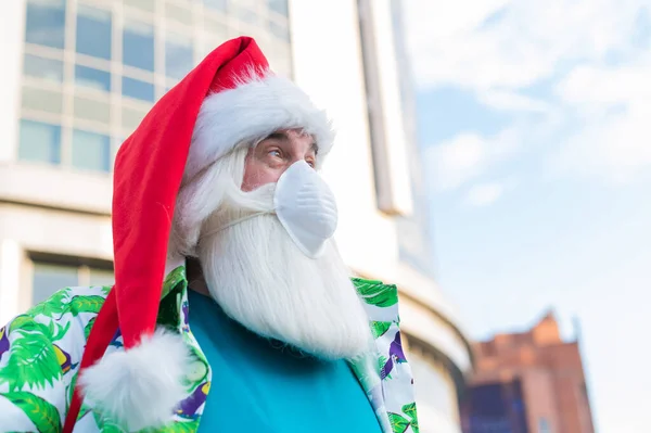 Retrato de santa claus en máscara protectora camisa hawaiana al aire libre. Navidad en el coronavirus —  Fotos de Stock