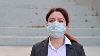 Mutsuz kovulmuş bir kadın elinde kişisel eşyalarıyla merdivenlerde oturuyor. Salgından dolayı işsizlik.