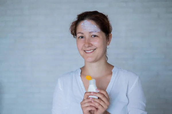 Portrait of a Caucasian woman with vitiligo diseas uses sunscreen — Stock Photo, Image