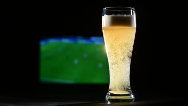 Une pinte de lager moussant et de football à la télévision. — Video