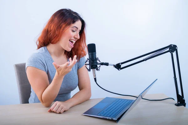 Eine emotionale Frau sendet online auf einem Laptop. Radiomoderatorin am Arbeitsplatz — Stockfoto